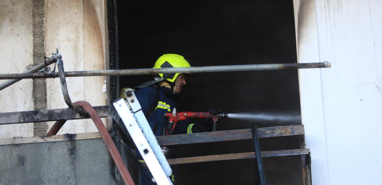 Πυροσβέστης σβήνει φωτιά σε διαμέρισμα
