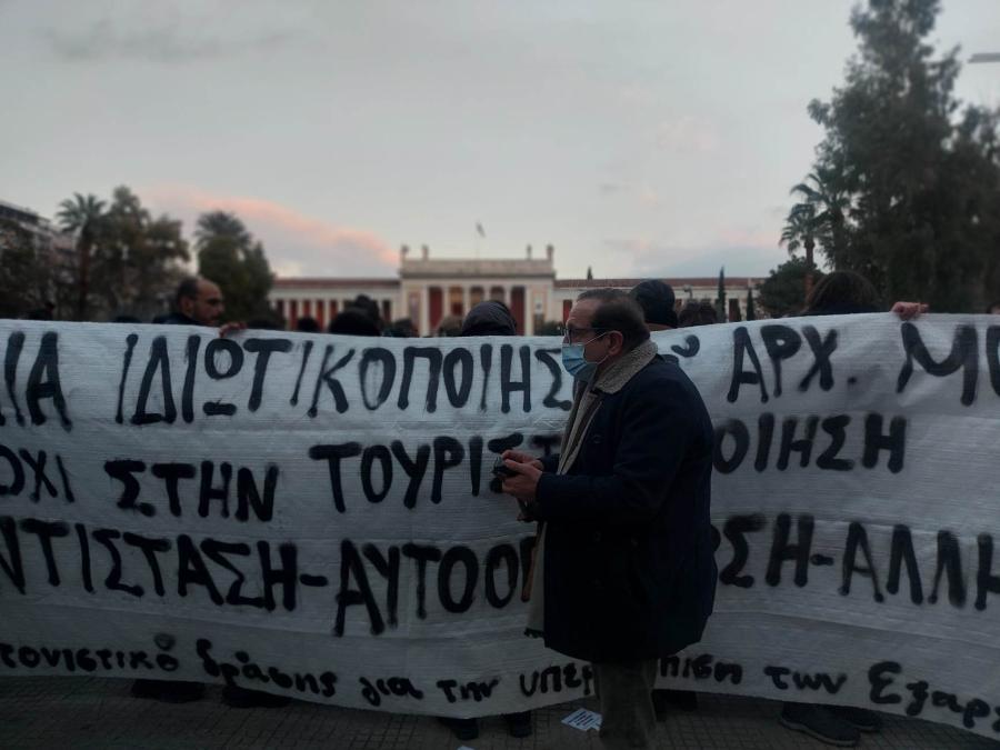 Διαδηλωτής μπροστά σε πανό για ιδιωτικοποίηση του Εθνικού Αρχαιολογικού Μουσείου