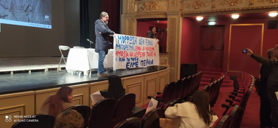 Άντρας με πανό πάνω στη σκηνή του δημοτικού θεάτρου Πειραιά