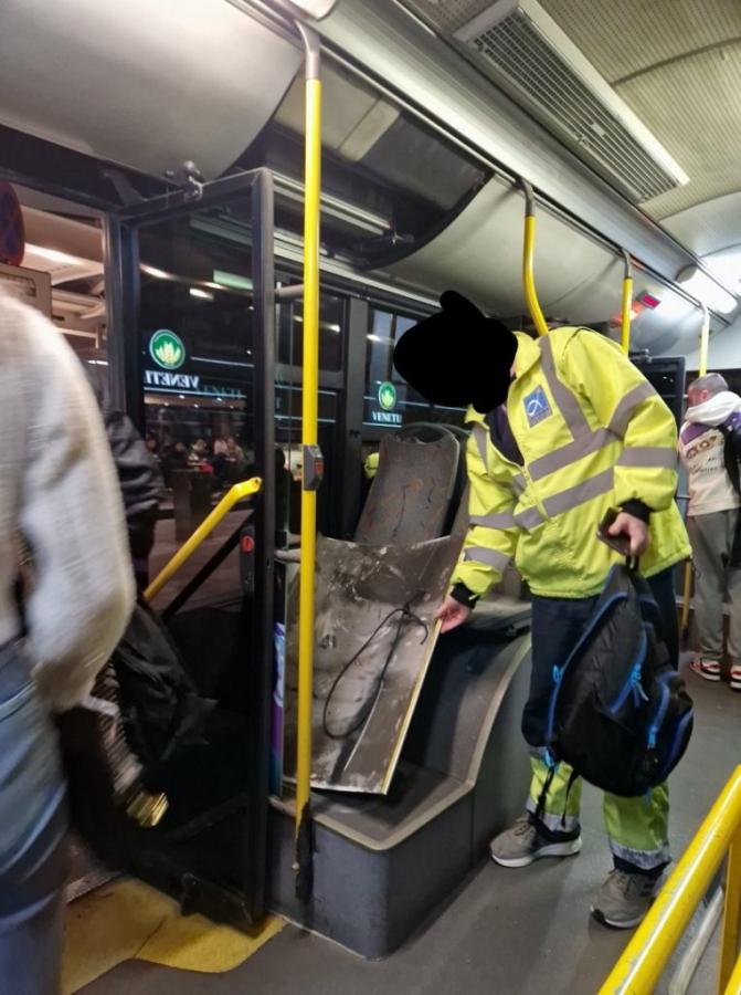 Άνδρας μαζεύει το κομμάτι της οροφής που έπεσε από τα καθίσματα του λεωφορείου