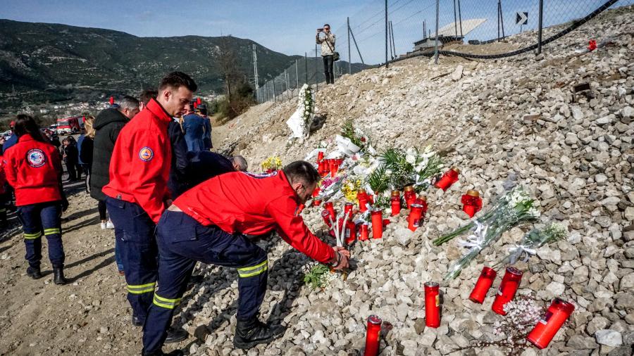 Διασώστες αφήνουν λουλούδια στο τόπο της τραγωδίας των Τεμπών