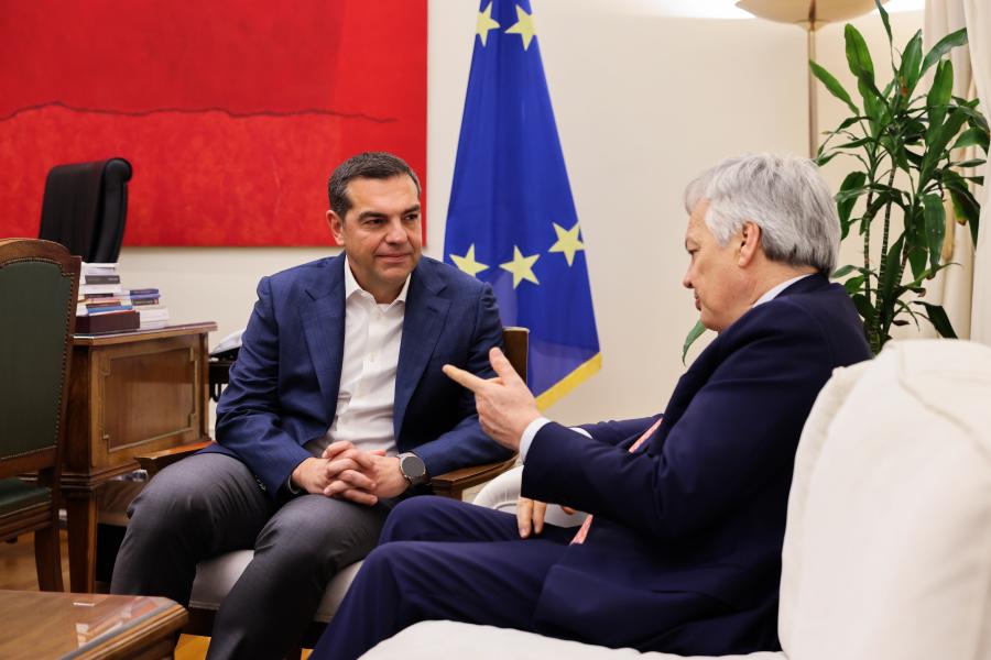 Ο Αλέξης Τσίπρας καθισμένος συζητά με τον Επίτροπο της ΕΕ αρμόδιο για θέματα Δικαιοσύνης, Ντιντιέ Ρέιντερς