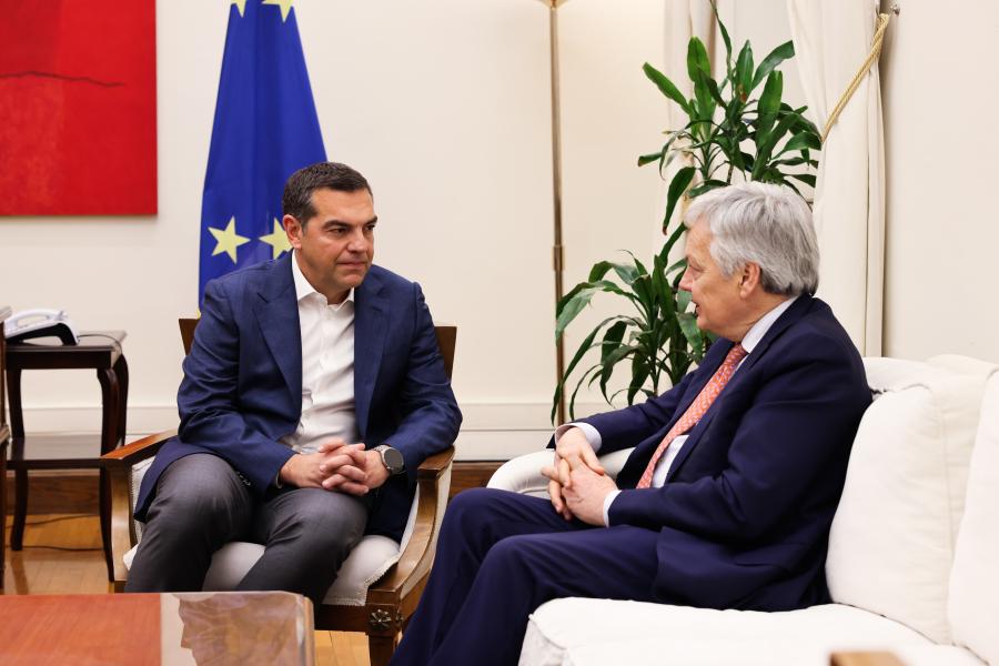 Ο Αλέξης Τσίπρας καθισμένος συζητά με τον Επίτροπο της ΕΕ αρμόδιο για θέματα Δικαιοσύνης, Ντιντιέ Ρέιντερς