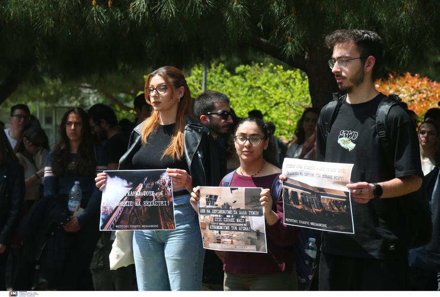 Φοιτητές με χαρτόνια στο χέρι με συνθήματα για την τραγωδία στα Τέμπη