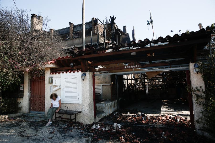 ηλικιωμένη κάθεται έξω από το σπίτι της που έγινε στάχτη από την φωτιά στο Λαογονήσι
