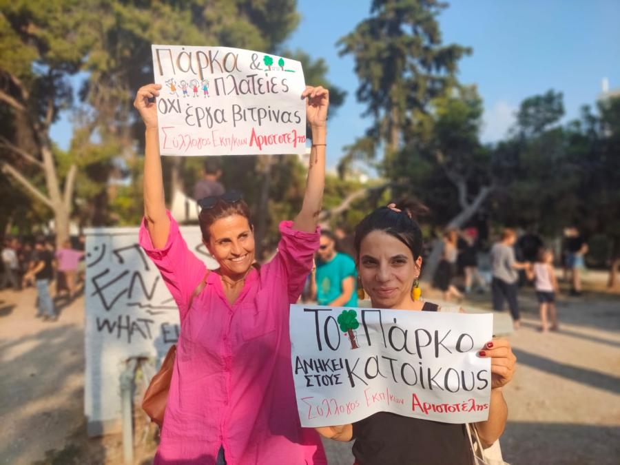 Κοπέλες με χαρτόνια που γράφουν συνθήματα στη διαμαρτυρία στο πάρκο Δρακόπουλου