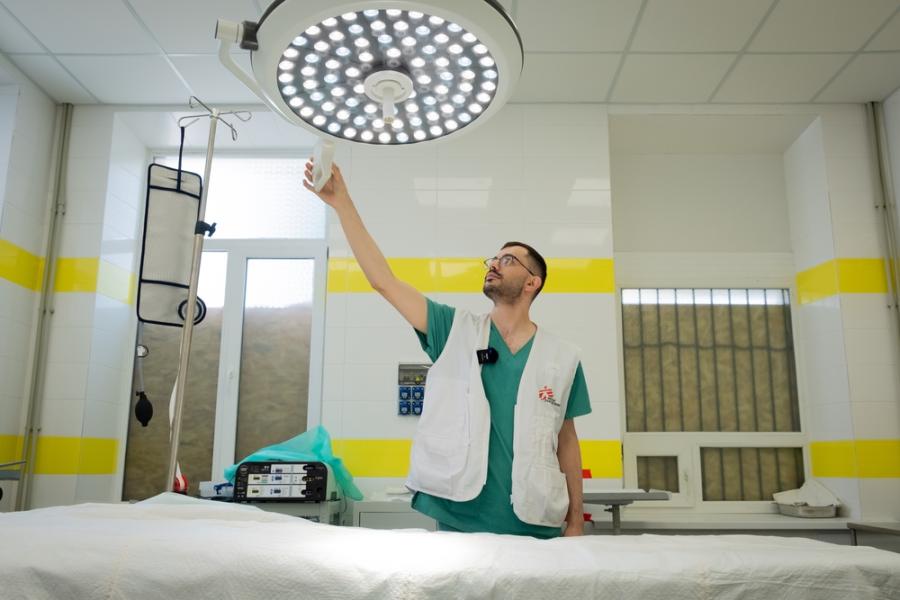 Ο Δρ Khassan El-Kafarna, γιατρός των Γιατρών Χωρίς Σύνορα, ρυθμίζει το φως στο χειρουργείο του νοσοκομείου Kostiantynivka. Οι ομάδες των Γιατρών Χωρίς Σύνορα μετέτρεψαν το ισόγειο φαρμακείο του νοσοκομείου σε χειρουργείο, για να ανταποκριθούν στην απότομη αύξηση των βομβαρδισμών και κατά συνέπεια, στην αύξηση του αριθμού των ασθενών που χρειάζονται επείγουσα χειρουργική επέμβαση. περιφέρεια Ντονέτσκ (επαρχία), Ουκρανία, Ιούνιος 2023.- Linda Nyholm/MSF