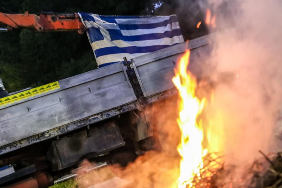 Φωτιά μπροστά σε ελληνική σημαία