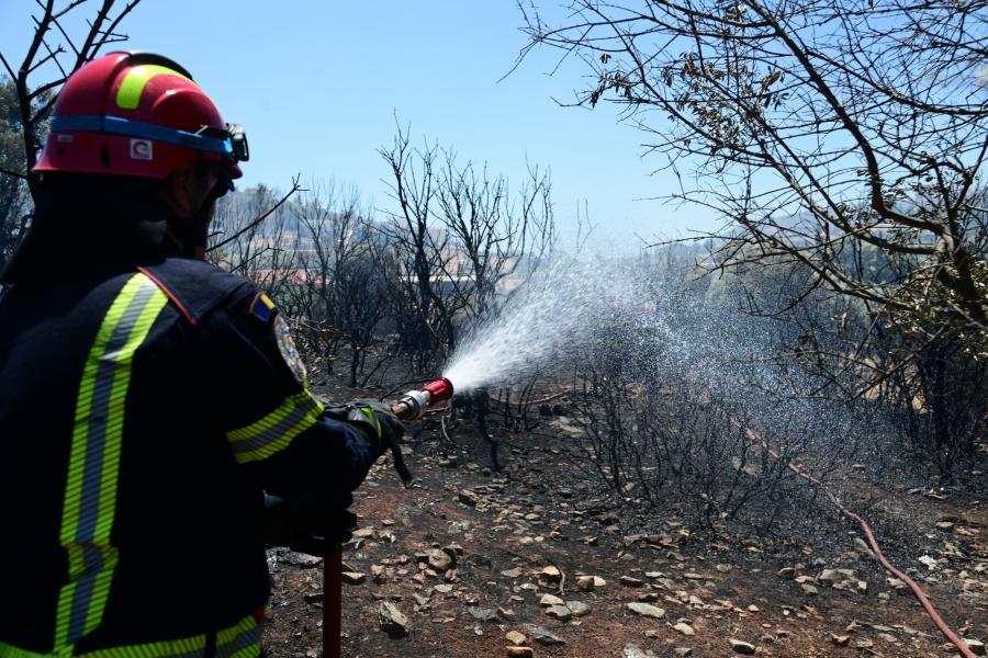 Πυροσβέστης ρίχνει νερό με μάνικα