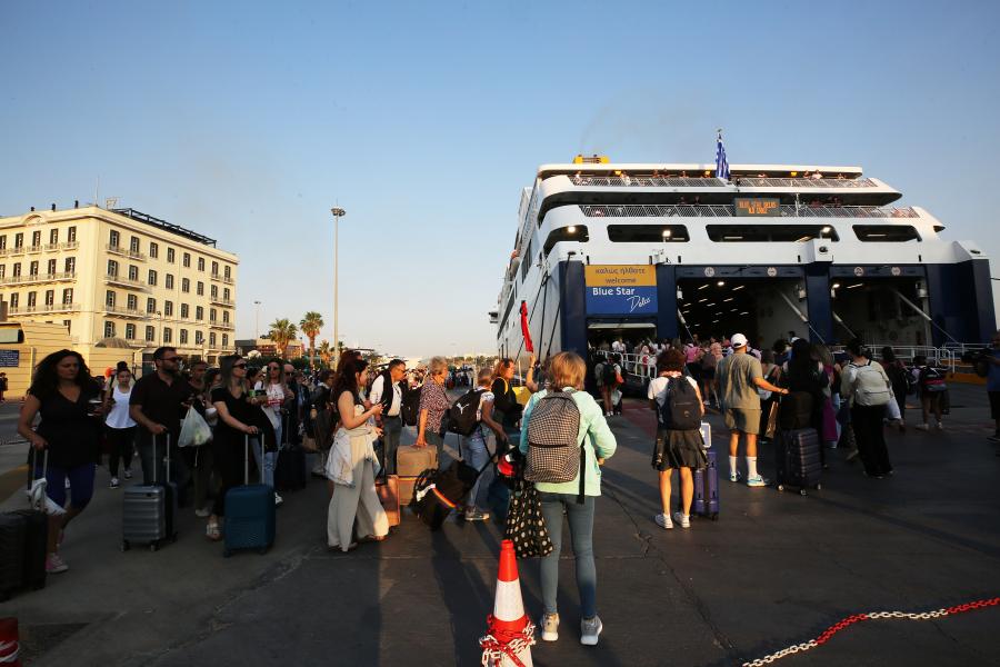 Ταξιδιώτες επιβιβάζονται σε πλοία στο λιμάνι του Πειραιά για τα νησιά των Κυκλάδων ενόψει του τριημέρου του Αγίου Πνεύματος