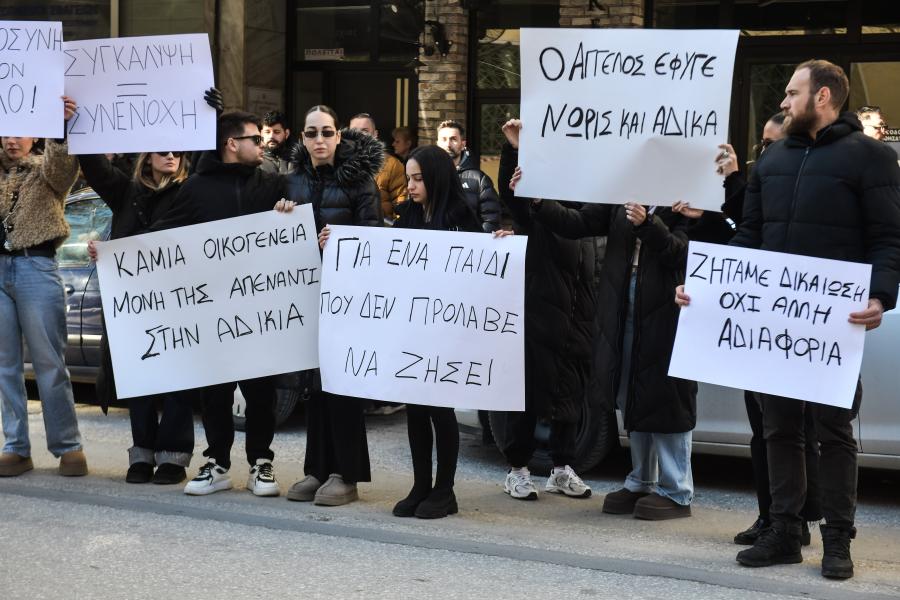 Συγγενείς και φίλοι του 17χρονου που ξυλοκοπήθηκε από τον 16χρονου με χαρτόνια που γράφουν συνθήματα έξω από τα δικαστήρια