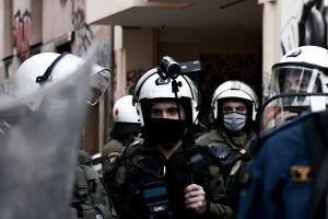 Αστυνομικός καταγράφει διαδηλωτές με κάμερα