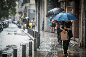 Κόσμος με ομπρέλες λόγω βροχής