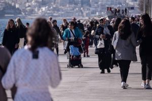 Κόσμος σε βόλτα δίπλα στη θάλασσα