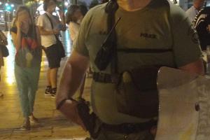Άνδρας των ΜΑΤ δείχνει το όπλο του