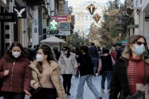 Άνθρωποι περπατούν στην Ερμου φορώντας μάσκα