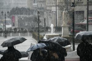 Άνθρωποι με ομπρέλες υπό βροχή