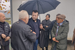 Ο Νίκος Παππάς μιλάει ανθρώπους μπροστά σε οικίσκους