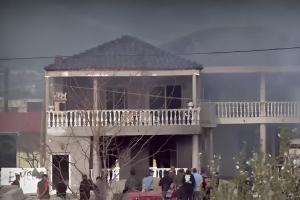 Κόσμος και άντρες της πυροσβεστικής στο σπίτι του δράστη το οποίο έχει περικυκλωθεί από καπνούς λόγω φωτιάς