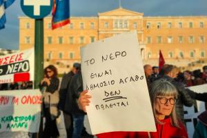 Γυναίκα στο Σύνταγμα κρατά χαρτόνι με σύνθημα κατά της ιδιωτικοποίησης του νερού