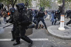 Αστυνομικοί με κράνη και αλεξίσφαιρα και ένας διαδηλωτής πεσμένος στον δρόμο στις διαδηλώσεις κατά της μεταρρύθμισης του συνταξιοδοτικού