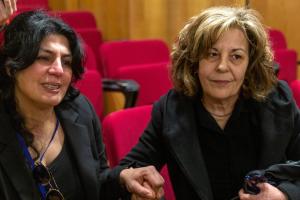 Η Serpil Unvar και η Μάγδα Φύσσα καθισμένες και κρατώντας η μία το χέρι της άλλης στο Εφετείο