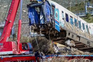 Γερανός σηκώνει κατεστραμμένο βαγόνι του τρένου που συγκρούστηκε στα Τέμπη