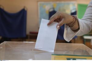 Χέρι γυναίκας που βάζει τον φάκελο μέσα στην εκλογική κάλπη