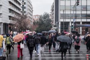 Κόσμος στο Σύνταγμα περνά την διάβασα κρατώντας ομπρέλες λόγω βροχής
