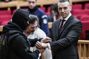 αστυνομικός βάζει τις χειροπέδες στον Κασιδιάρη στην αίθουσα του δικαστηρίου