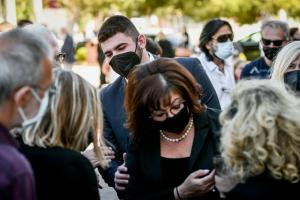 Η χήρα και ο γιος του Γιώργου Καραϊβάζ με κόσμο τριγύρω στην κηδεία του δημοσιογράφου