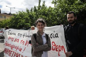 Η Σταυρούλα Πουλημένη δίπλα σε ένα άντρα που κρατά την άκρη ενός πανό