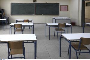 Άδεια σχολική αίθουσα με θρανία που κοιτούν προς τον πίνακα