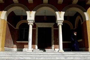 Κτίριο της Ιεράς Συνόδου Κύπρου με παπά να προχωρά στα σκαλιά