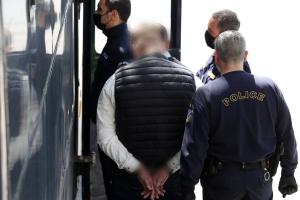 Άνθρωπος με χειροπέδες δίπλα σε αστυνομικό