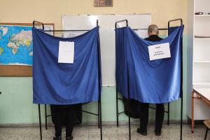 Ψηφοφόροι πίσω από το παραβάν σε εκλογικό κέντρο