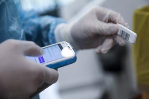 χέρια γιατρού με στολή που κρατάνε τεστ για κορωνοϊό