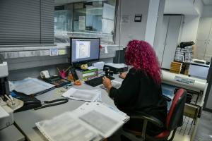 Υπάλληλος εργάζεται στο γραφείο της μπροστά στον υπολογιστή