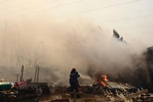 Πυροσβέστης ρίχνει με την μάνικα νερό για να σβήσει φωτιά