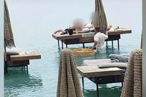 Σερβιτόρος μέσα στη θάλασσα σερβίρει πελάτες beach bar στην Ρόδο