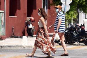 Άνθρωποι με μάσκα περπατούν στον δρόμο
