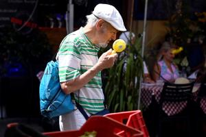 Ηλικιωμένος κρατάει στο χέρι ανεμιστηράκι για τη ζέστη