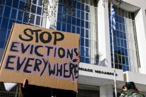 Χαρτόνι με σύνθημα στα αγγλικά «σταματήστε τις εξώσεις παντού»