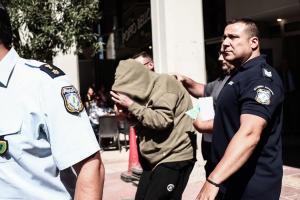 Άνθρωπος με κουκούλα δίπλα σε αστυνομικό