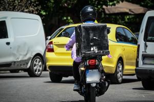 Διανομέας στον δρόμο με το μηχανάκι του