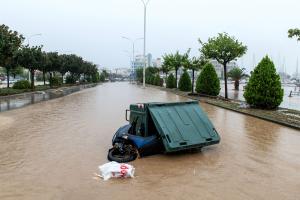 Πεσμένο μηχανάκι μπλεγμένο σε κάδο σκουπιδιών σε πλημμυρισμένο δρόμο στο Βόλο
