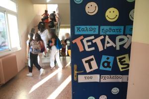 πόρτα τάξης με χαρτόνι που γράφει «καλως ήρθατε» και παιδιά πίσω να ανεβαίνουν τις σκάλες του σχολείου