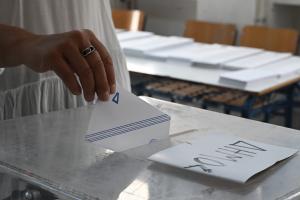 Χέρι γυναίκας βάζει φάκελο σε κάλπη
