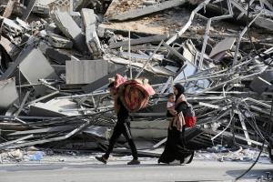 Άνθρωποι περπατούν μπροστά στα χαλάσματα