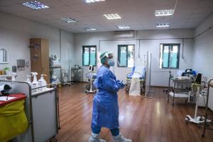 Γιατρός με ειδική στολή για covid-19 σε αίθουσα εμβολιαμσού
